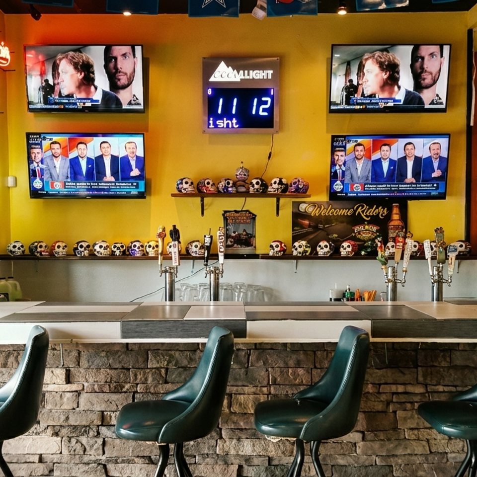 Sports bar counter with four green stools, multiple televisions, beer taps, colorful skull decorations, and beverage shelves.
